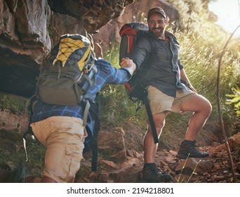 Nature, Fitness And Hiking Friends Climbing Up Rocks On A Mountain Hike Trail During Spring. Fit Men Holding Hands To Help And Support Trekking Up Stones With A Backpack On Adventure Health Workout.