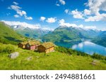 Nature in fjords. Rakssetra, Norway. Panoramic view. Traveling on a Norwegian fjord. Scandinavia. Traditional old settlement. Houses with moss on the roof. Vacation and travel in summer Norway.