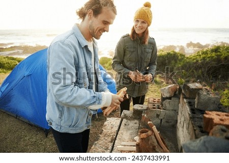 Nature, happy and couple with fire for camping on romantic vacation, adventure or holiday. Smile, love and young man and woman with flame for warm on outdoor winter weekend trip with tent together.