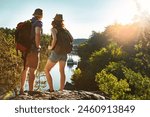 Nature, hiking and couple at lake on adventure holiday in mountain with trees, sun, and bush from back. Trekking, man and woman on travel vacation together in woods, forest or outdoor climbing park