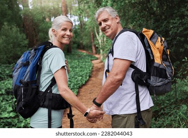 Nature, hiking and portrait of old couple holding hands on adventure in forest, woods and mountain for exercise. Fitness, retirement and happy elderly man and woman smile trekking for travel wellness - Powered by Shutterstock