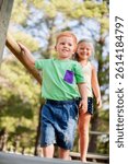 Nature, jungle gym and children in park playing together for school holiday, adventure or exploring. Happy, bonding and kid siblings climb on playground equipment outdoor for fun, activity or freedom