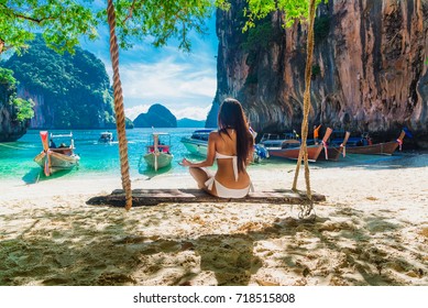 Nature for life, Healthy woman in bikini relaxing on swing practicing yoga pose on destination natural island, Krabi, Wellness girl traveling tropical sea beach Thailand, Summer vacation travel trip