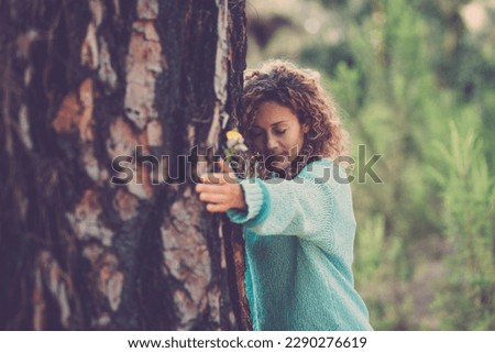 Nature love and environment. Sustainable lifestyle people. One woman bonding a big trunk tree in the forest woods. Concept of natural protection. Green woods background. Stop deforestation outdoors