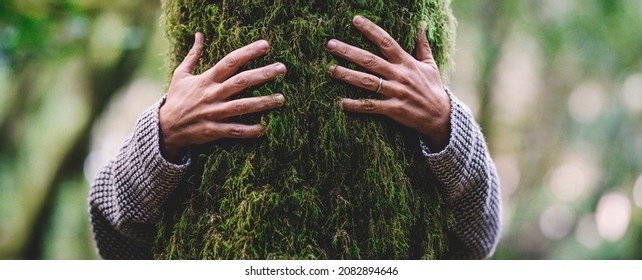 Nature lover hugging trunk tree with green musk in tropical woods forest. Green natural background. Concept of people love nature and protect from deforestation or pollution or climate change - Shutterstock ID 2082894646
