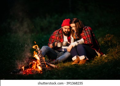Nature lovers on sitting around the campfire at night