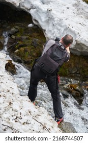 Nature Photographer Shooting A Waterfall Through The Snow