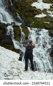 Nature Photographer Shooting A Waterfall Through The Snow