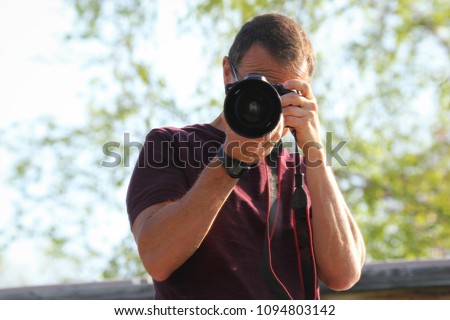 nature photographer taking a picture being the main focus