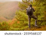 Nature photographer. Young male photographer autumn season outdoors portrait. Back view. Landscape photographer taking photos.