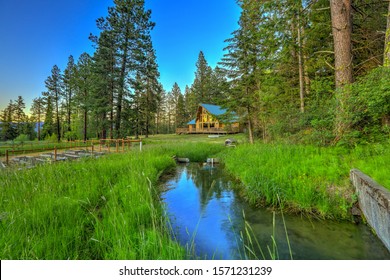 Nature With Pine Trees And Mountains And Beautiful Chalet Cider Home Land During Summer.