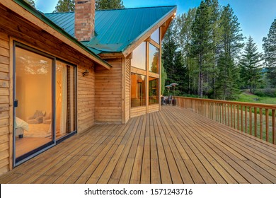 Nature With Pine Trees, Mountains And Beautiful Chalet Cider Home Exterior With Bedroom Interior View.