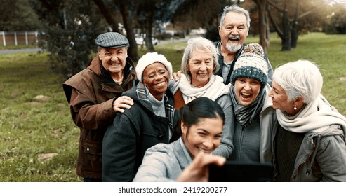 Nature, selfie and senior friends with woman while walking in outdoor garden for fresh air. Diversity, happy and group of elderly people in retirement taking picture with young female person in park. - Powered by Shutterstock