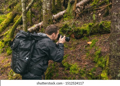 Nature still photography photographer man with professional slr camera taking picture of wild mushroom in forest during trail hike. - Powered by Shutterstock