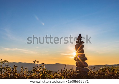 Nature stones stacked on abstract sunset background