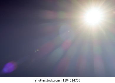 Nature Sun light radiation of lens fare with spectrum for background, backdrop, template & wallpaper. The bright sun shines on a blue sky background, Copy space.  Realistic sun burst with flare. - Shutterstock ID 1194814735