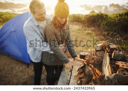 Nature, sunset and couple with fire for camping on romantic vacation, adventure or holiday. Happy, love and young man and woman with flame for warm on winter weekend trip with tent together.
