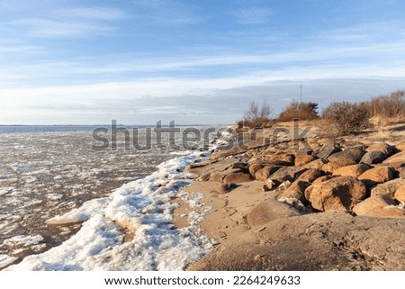 
Nature view on a sunny winter day with a sea view of brown rocks and light blue sky