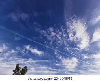 Nature's Brushstrokes: Sunlight-kissed clouds etch their delicate textures on a canvas of brilliant blue sky
