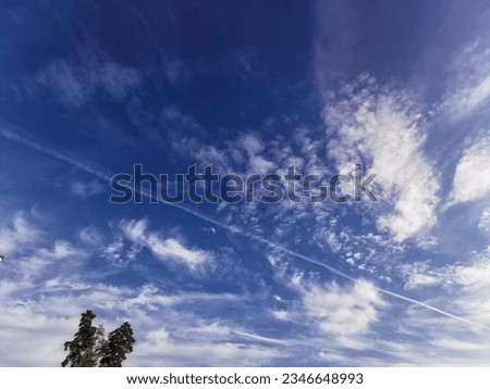 Nature's Brushstrokes: Sunlight-kissed clouds etch their delicate textures on a canvas of brilliant blue sky