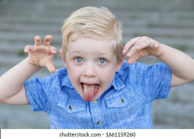 A Naughty Child Grimaces And Shows His Tongue. The Concept Of Childhood, Parenting And Care.