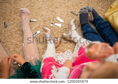 Naughty children are tired and sit on the floor and watch cartoons. Legs of children close up.
