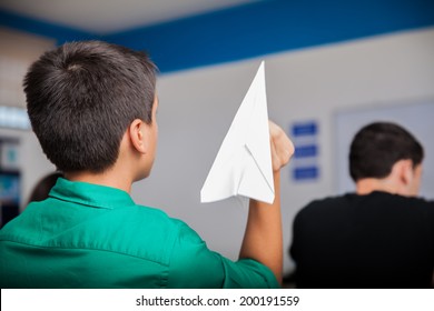 Naughty high school student throwing a paper plane during class - Powered by Shutterstock