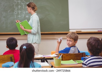 Naughty pupil about to throw paper airplane in class at the elementary school - Powered by Shutterstock