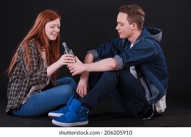 Naughty Teenagers Sitting On Ground And Drinking Alcohol