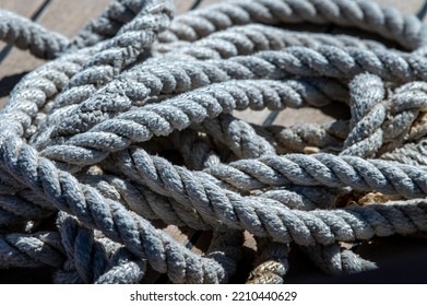 Nautical Consumed Thick Rope Coil On Wooden Boat Deck 