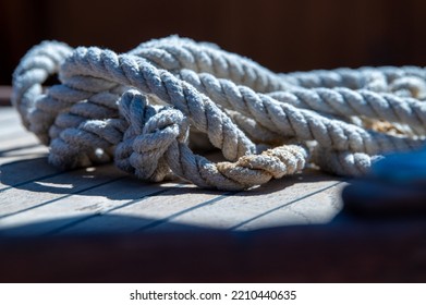 Nautical Consumed Thick Rope Coil On Wooden Boat Deck 