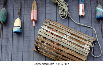 Nautical decoration of lobster trap and colorful buoys on exterior wall of seafood restaurant.