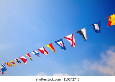 Nautical flags against blue sky