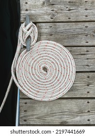 Nautical Style Rope Wound Up into a Spiral Circle on a Boat Dock.