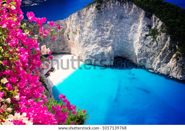 Navagio beach, famous overhead summer\
lanscape of Zakinthos island, Greece with\
flowers