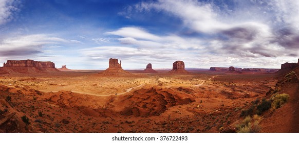 Navajo Reservation in Arizona, USA. Panoramic View on the beautiful red-orange rocks in light of the white-purple sunset in Monument Valley.