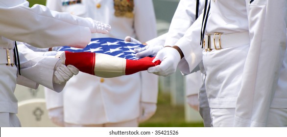 Naval Honor Guard Folding US Flag Over Casket During Funeral At Arlington National Cemetery