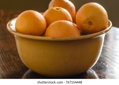 Navel Oranges In Bowl On Wood Table In Natural Light