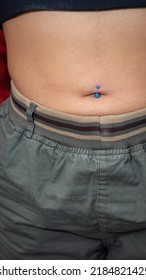 Navel Piercing. Placement Of Implant Grade Titanium Precious Jewelry With Opal Stone Inlay.p