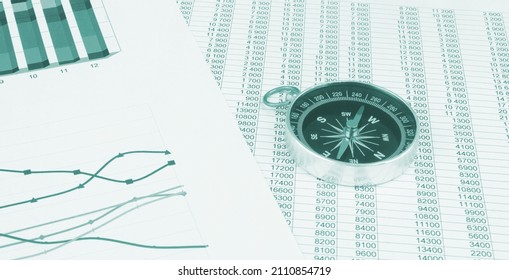 Navigation in financial world, compass on financial charts and graphs.