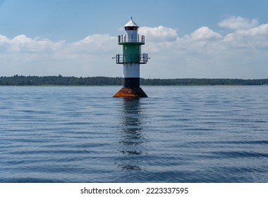 Navigation green buoy or beacon on in the calm blue sea water