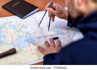 navigation with sea charts in the chart room on a sailing yacht - Shutterstock ID 772981621