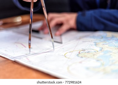 navigation with sea charts in the chart room on a sailing yacht - Shutterstock ID 772981624
