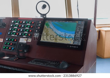 Navigational bridge on big cargo ship. Wheelhouse on vessel. ECDIS, radar.