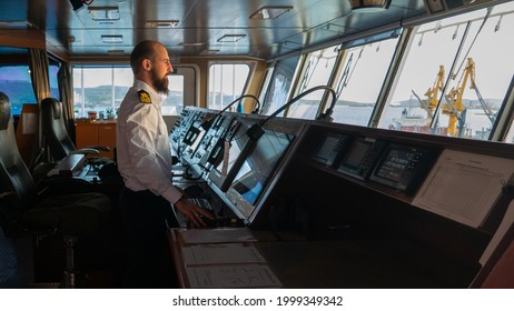 Navigational merchant officer watching keeping navigational watch on the bridge and watching ECDIS and radar - Shutterstock ID 1999349342