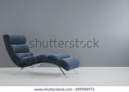 Navy blue chaise lounge with metallic elements in spacious apartment