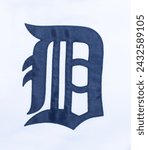 A navy blue letter D in Collins Old English Regular font.  Fabric stitched Detroit tigers American professional major league baseball brand logo photo from their jersey.  isolated on white background