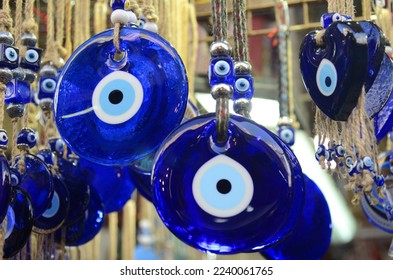 Nazar in market. Blue and red Fatima eye close-up protective amulet against evil eye. Israeli and turkish souvenir. decorative glass blue souvenirs in the form of an eye