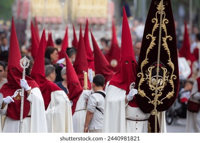 Nazareno, bearer in a procession of the easter week in Seville, andalusia, Spain. 2024 Semana Santa. Red hood, procession of 23.03.2024 - Powered by Shutterstock