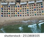 Nea Peramos, September 7, 2024. Beach umbrellas on the sand on the beach at the seaside in Greece, shot by drone